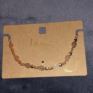 A gold pineapple ankle bracelet